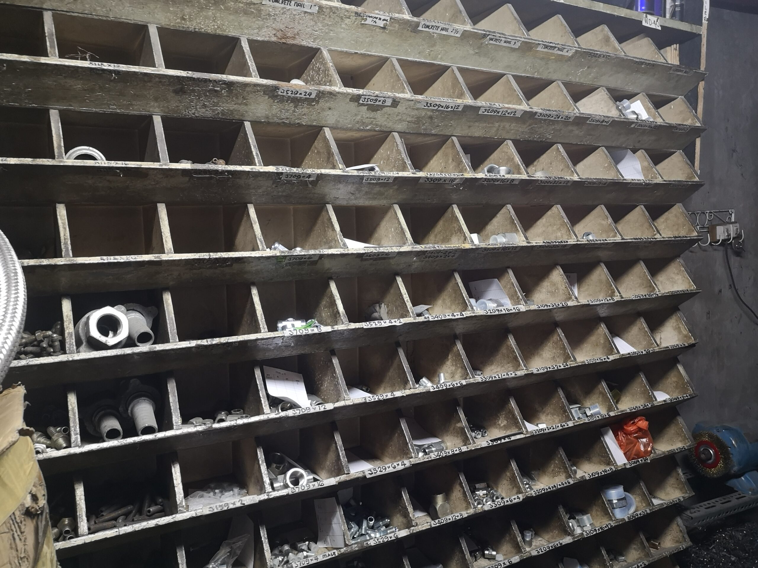 Inside the Cresty Trading warehouse in Manila: shelves stocked with hydraulic hoses, fittings, ferrules, and pneumatic parts
